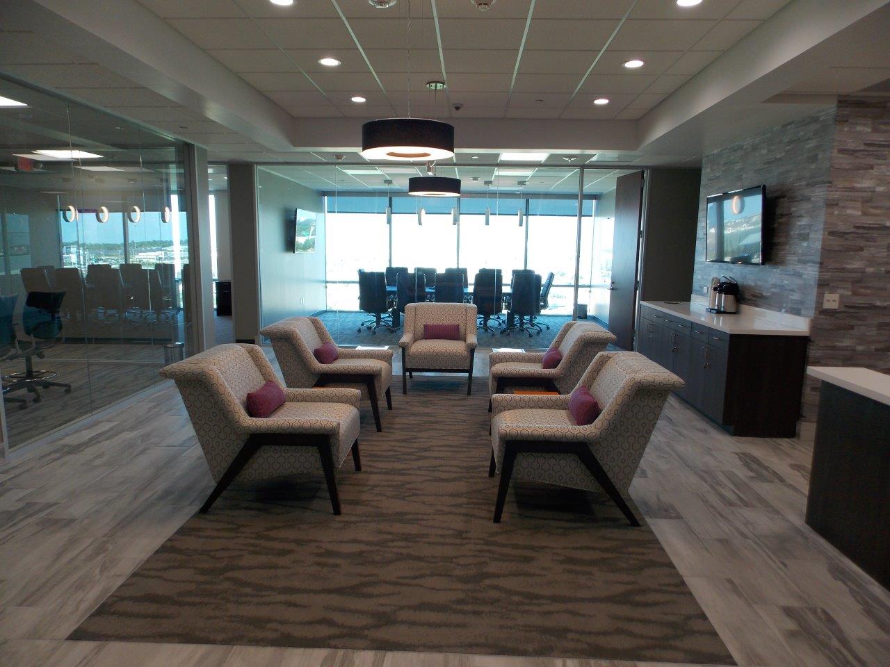 A room with a lot of chairs and a conference room in the background