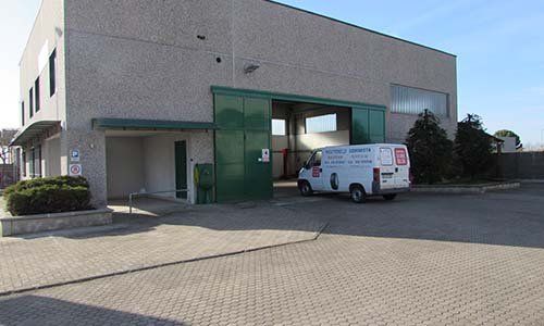 un furgone bianco fuori da uno stabile industriale