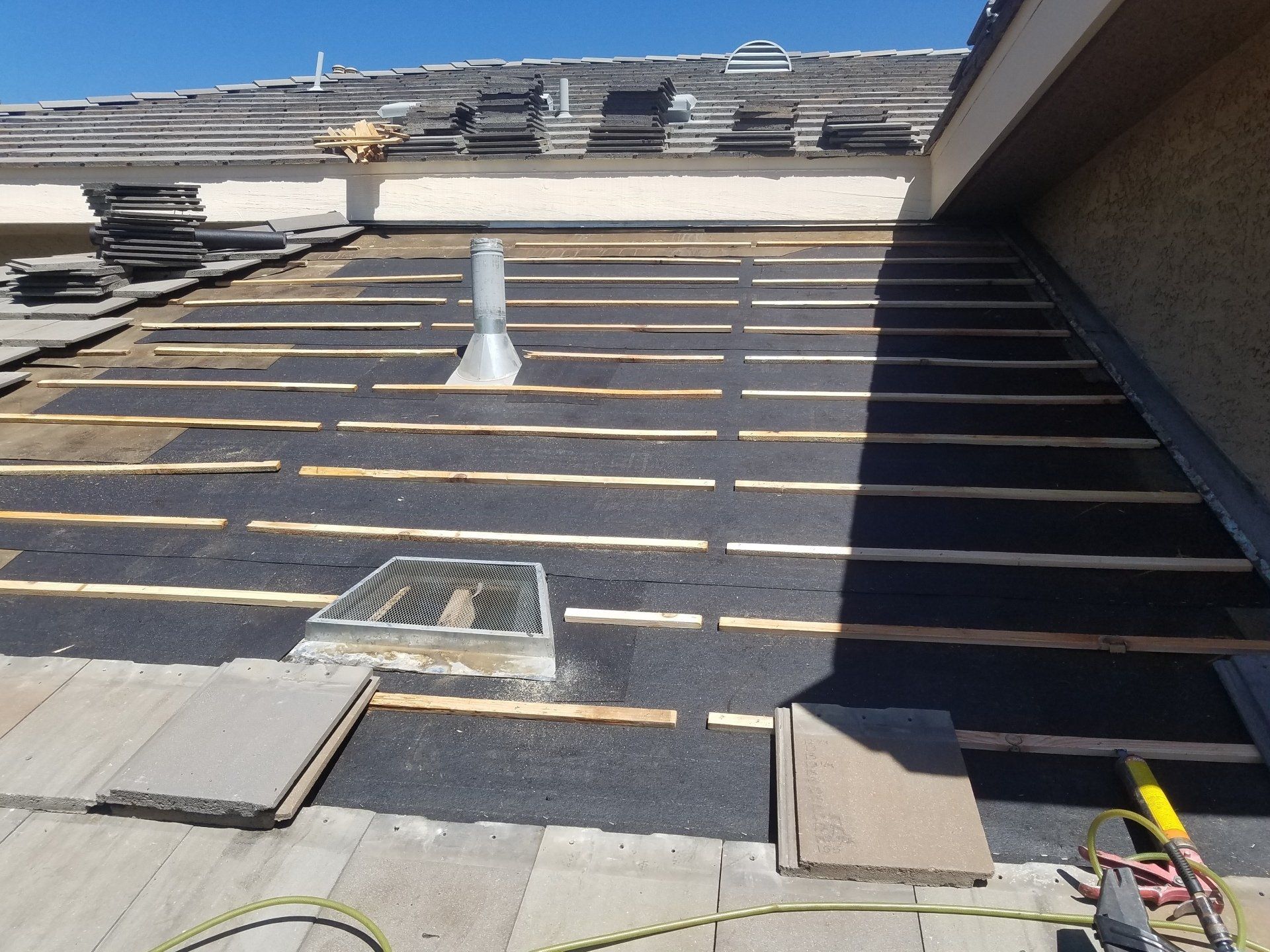 The roof of a building is being remodeled and the shingles are being removed