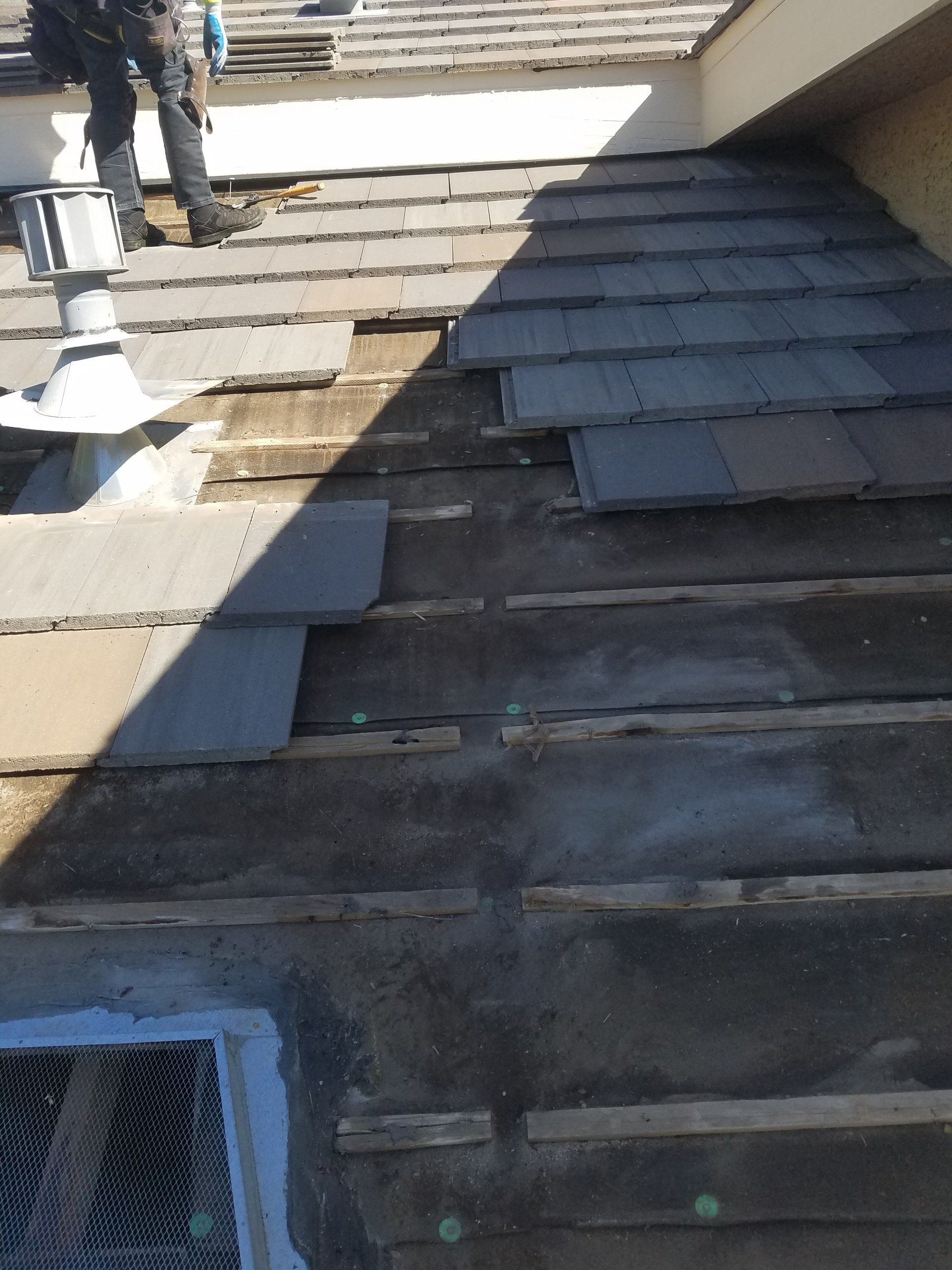 A man is working on the roof of a building