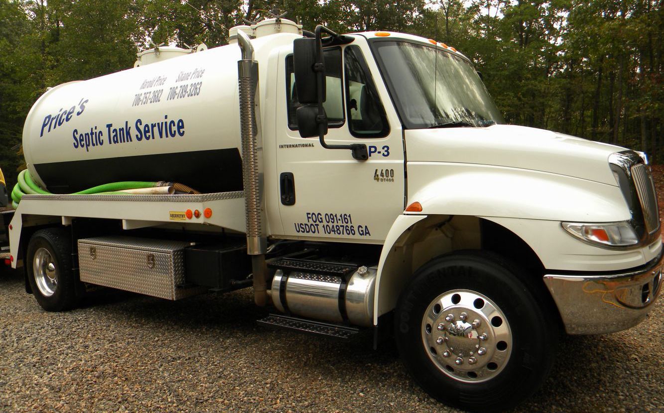White septic tank service truck parked outdoors.
