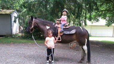 Young girl leading another young girl on horse - Horse riding lessons in Olalla WA Young girl leading another young girl on horse - Horse riding lessons in Olalla WA