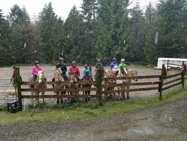 Riders on horses in by arena fence - Horse riding lessons in Olalla WA Riders on horses in by arena fence - Horse riding lessons in Olalla WA