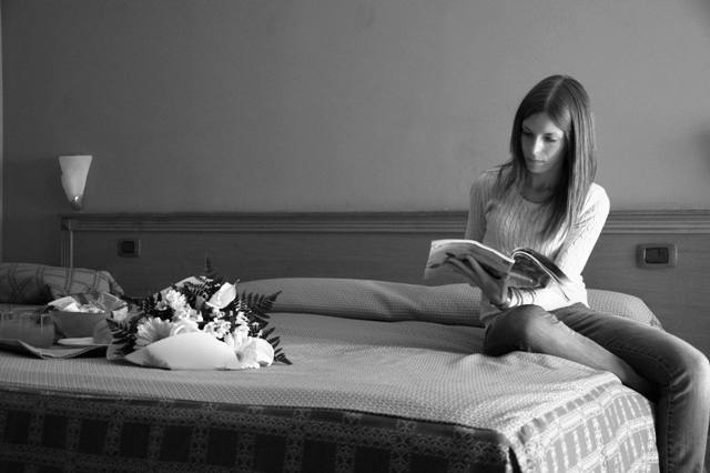 fotografia di una ragazza che legge su un letto di un resort