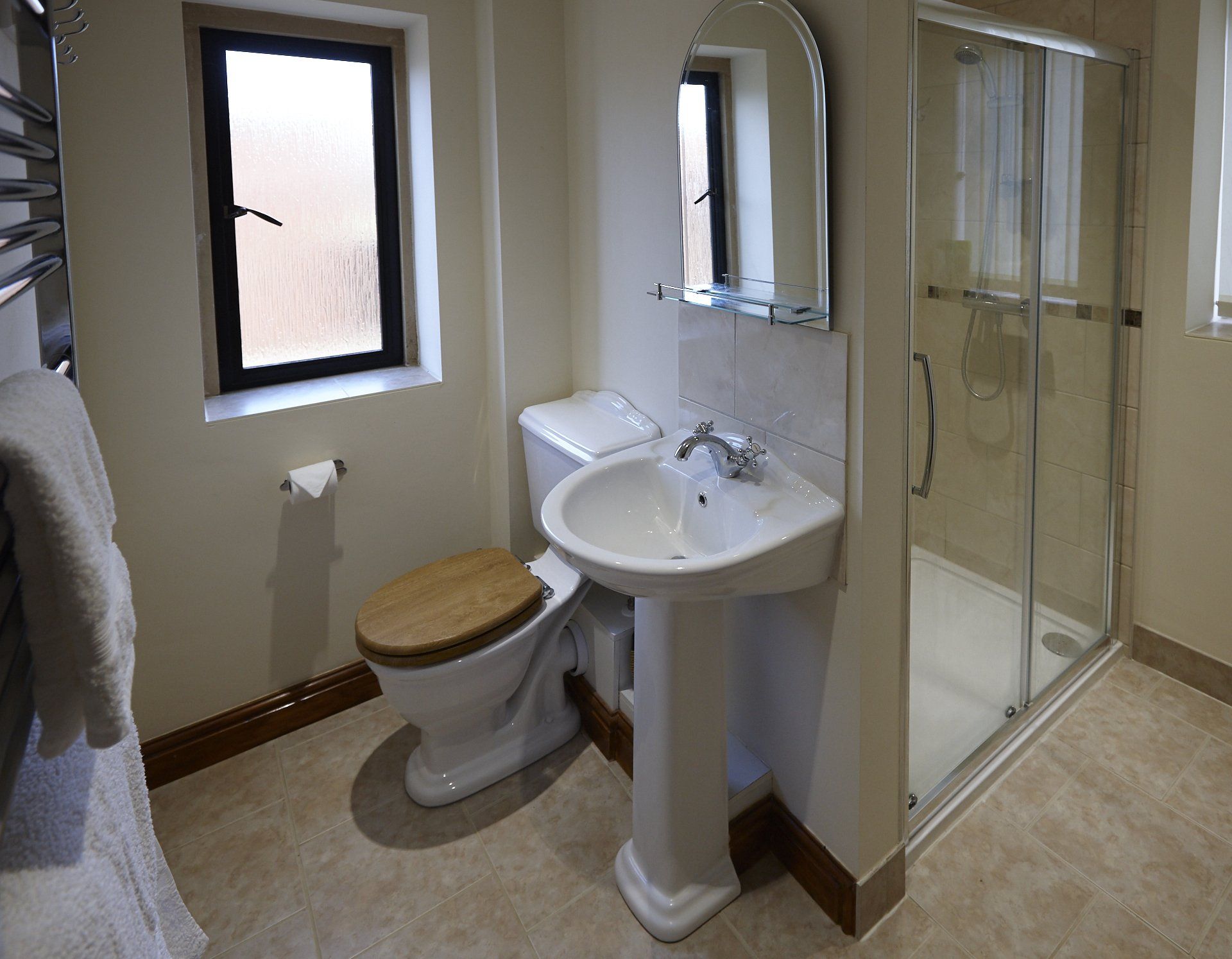 A bathroom with a toilet , sink and shower.