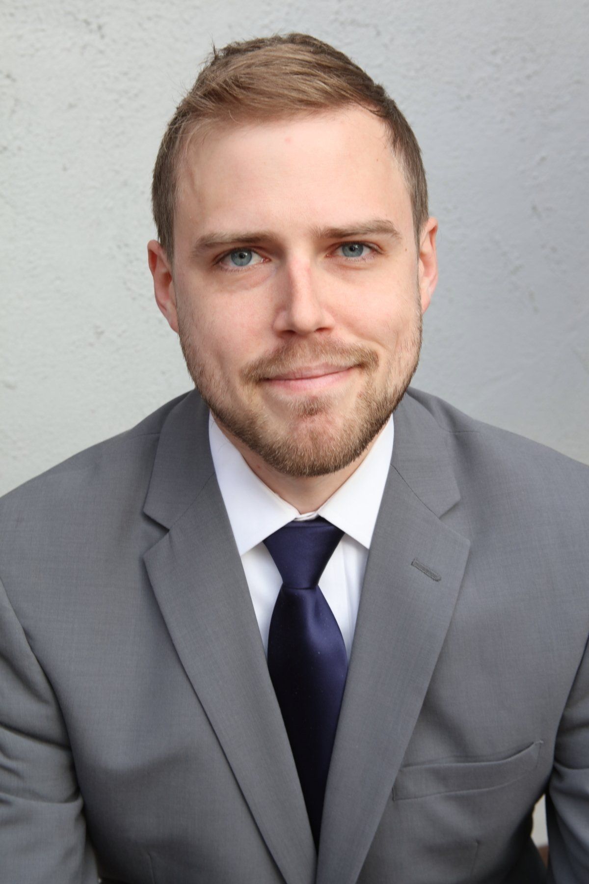 A man in a suit and tie is smiling for the camera.