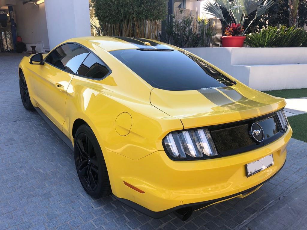 Ceramic tint a yellow Mustang sports car rear view