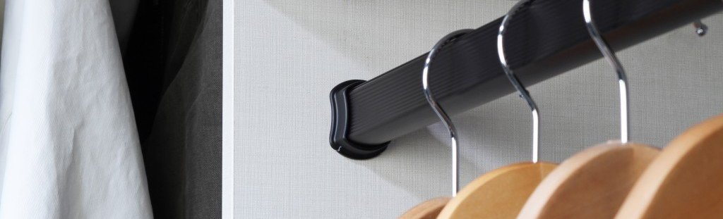 A close up of a clothes rack with clothes hanging on it.