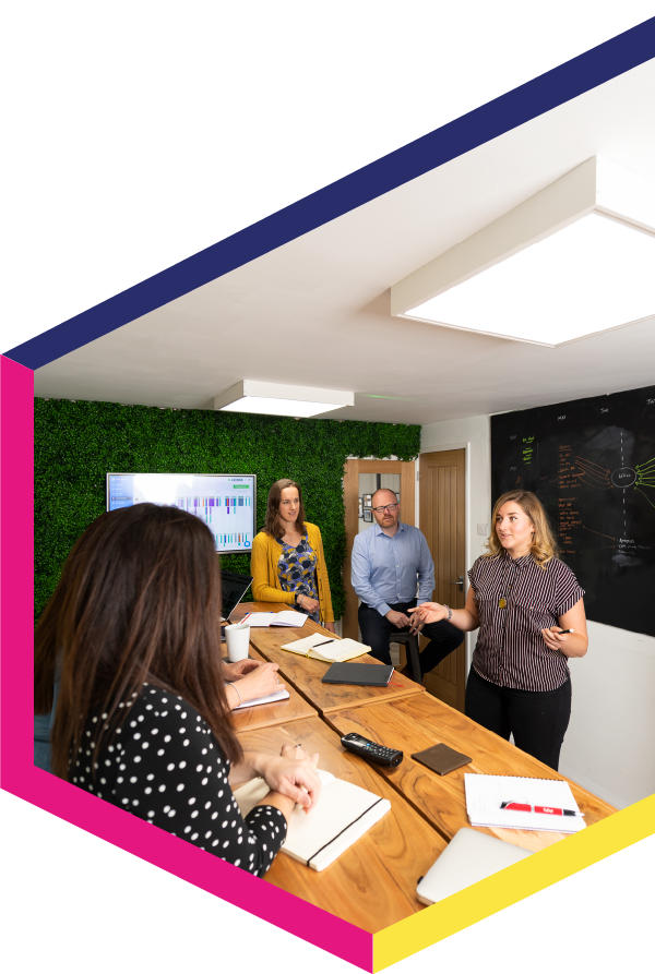 A group of people are sitting around a table in a conference room.
