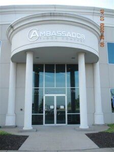 Entrance to the Ambassador building with white columns and glass doors