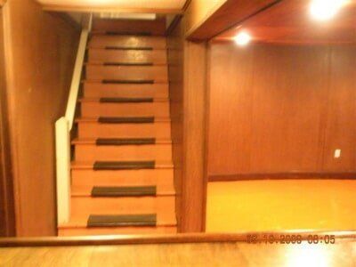 Wood-paneled room with a narrow staircase leading up to a loft or upper level.