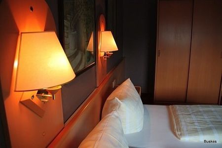 Ein Hotelzimmer mit einem Bett und zwei Lampen an der Wand
