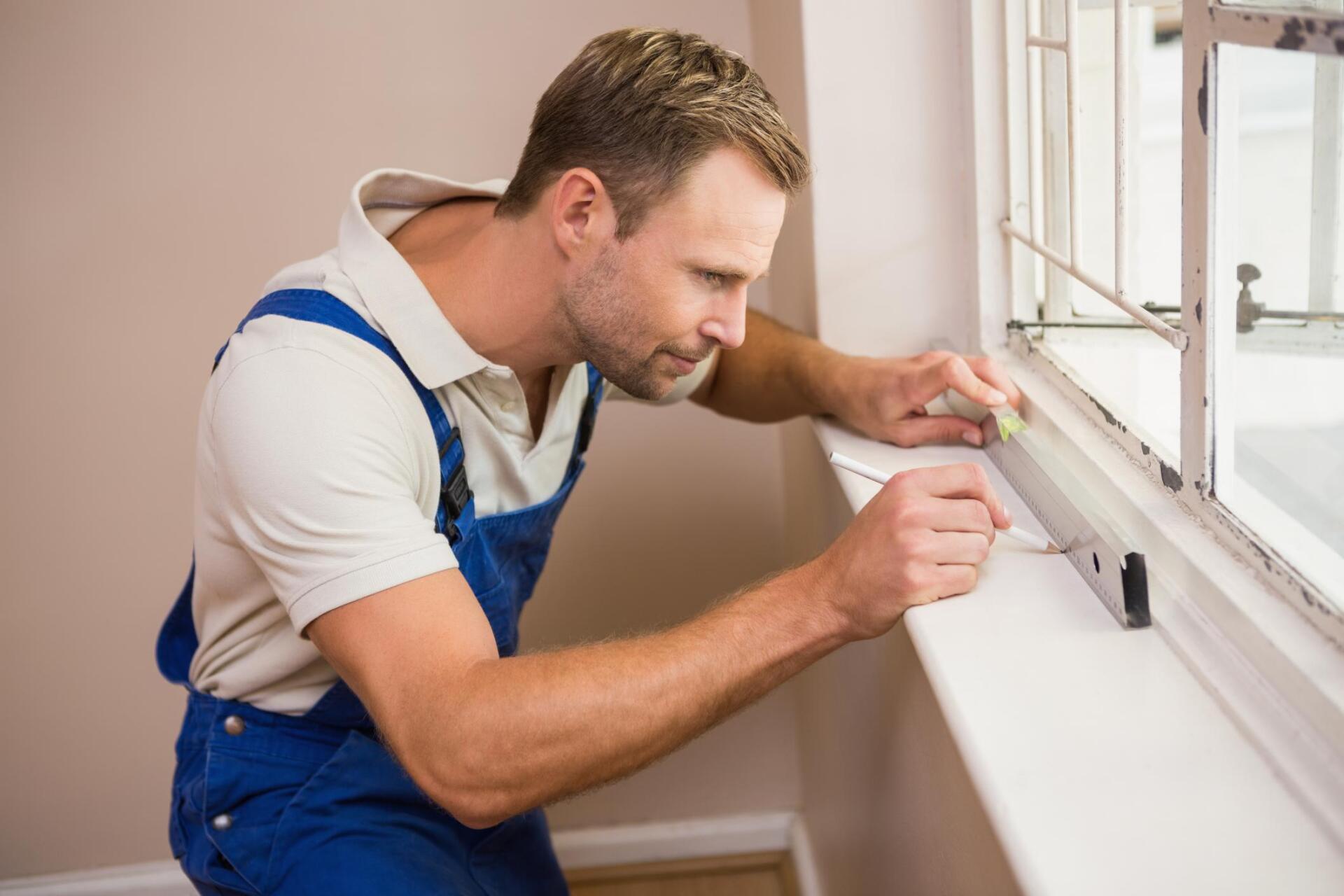 man doing markings in window