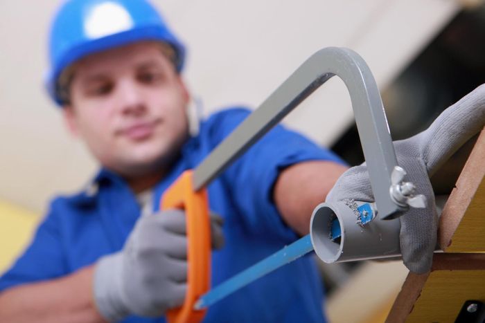 a plumber cutting the pipe