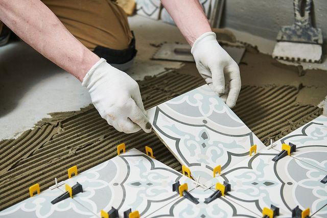 someone installing tile flooring
