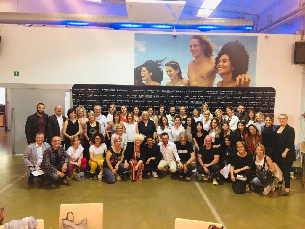 Fotografía de grupo de unas 50 personas en un interior frente a una pancarta.