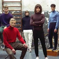 Cinco personas con cuellos de tortuga y pantalones posan en un entorno rústico; los colores varían del rojo al azul.