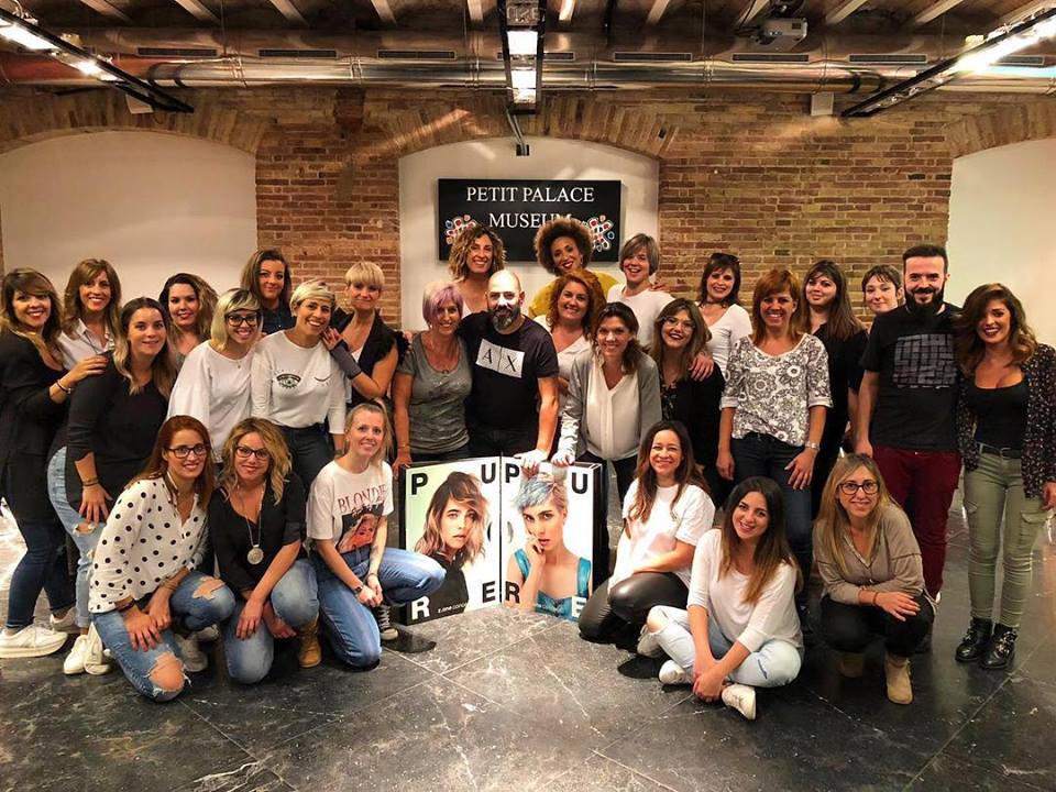 Retrato grupal de un equipo en el Hotel Petit Palace. Muchos sonrientes, con carteles de moda.