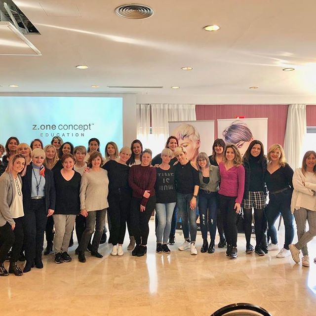 Grupo de mujeres en un evento con una pantalla de presentación que dice