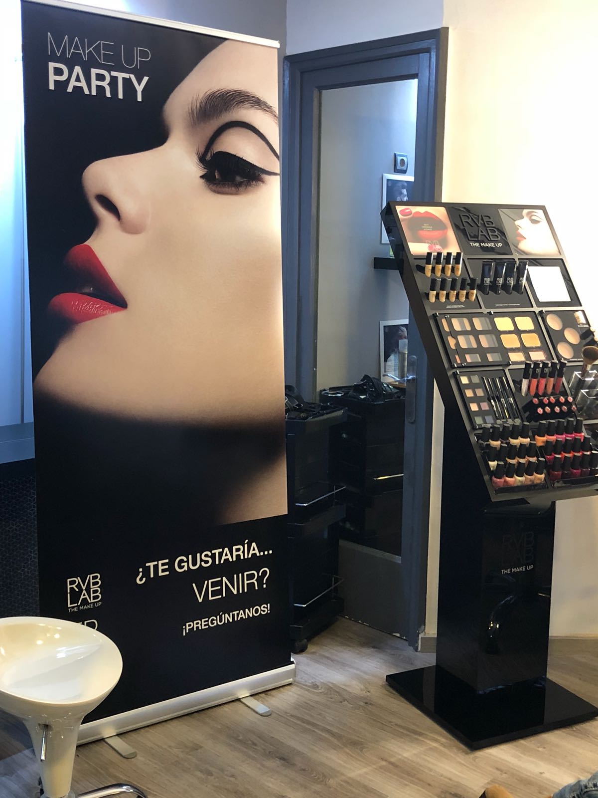 Expositor de maquillaje con pancarta promocional con el rostro de una mujer. Decoración interior con productos de maquillaje.
