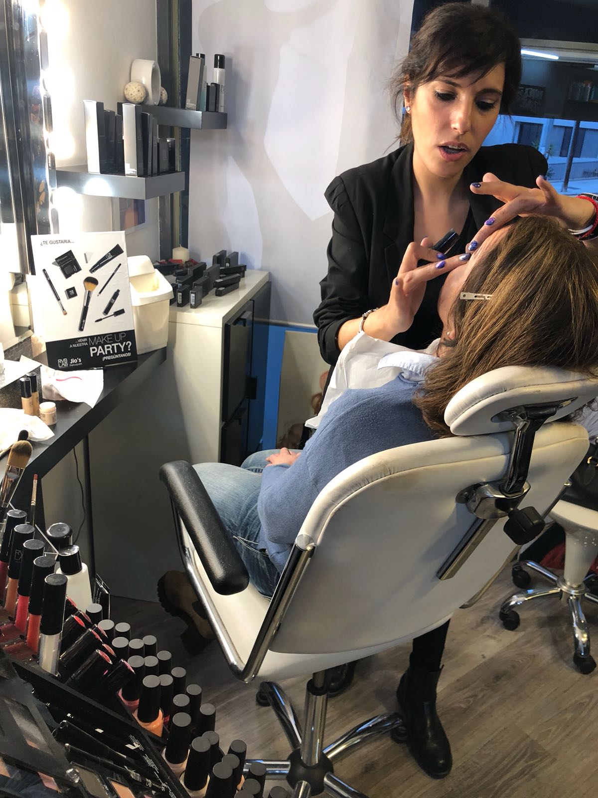Un maquillador aplica maquillaje a un cliente en un salón.