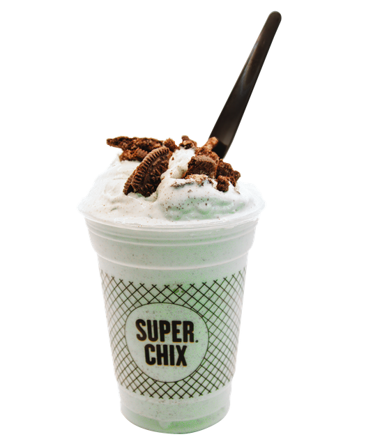 Mint milkshake with chocolate pieces in a Super Chix branded cup and black spoon.