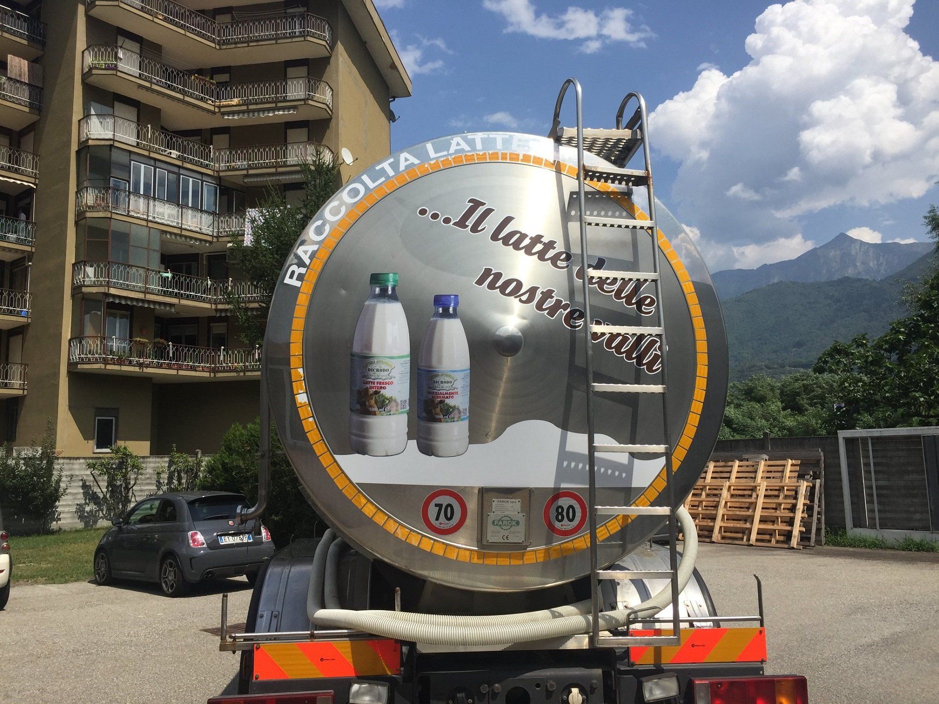 A milk tanker truck features graphics of milk bottles and the text