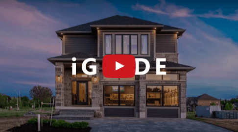 Two-story house with stone and dark siding, large windows, and a play button overlay, set at dusk.