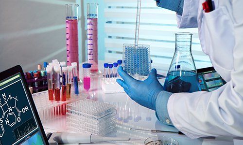 un uomo con un camice bianco in un laboratorio mentre fa degli esami