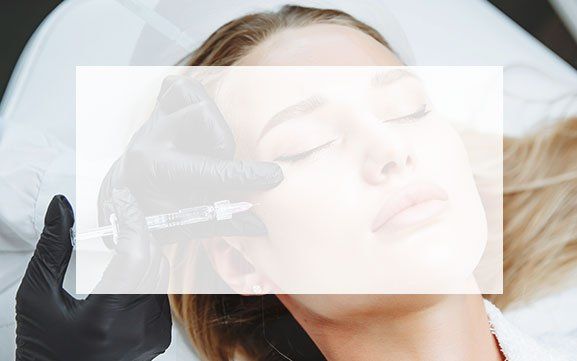 A woman is getting a botox injection in her face.