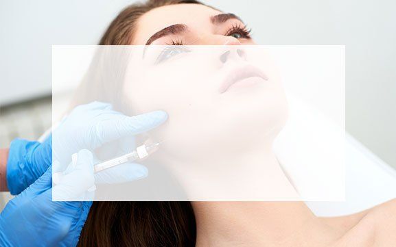 A woman is getting a botox injection in her face.