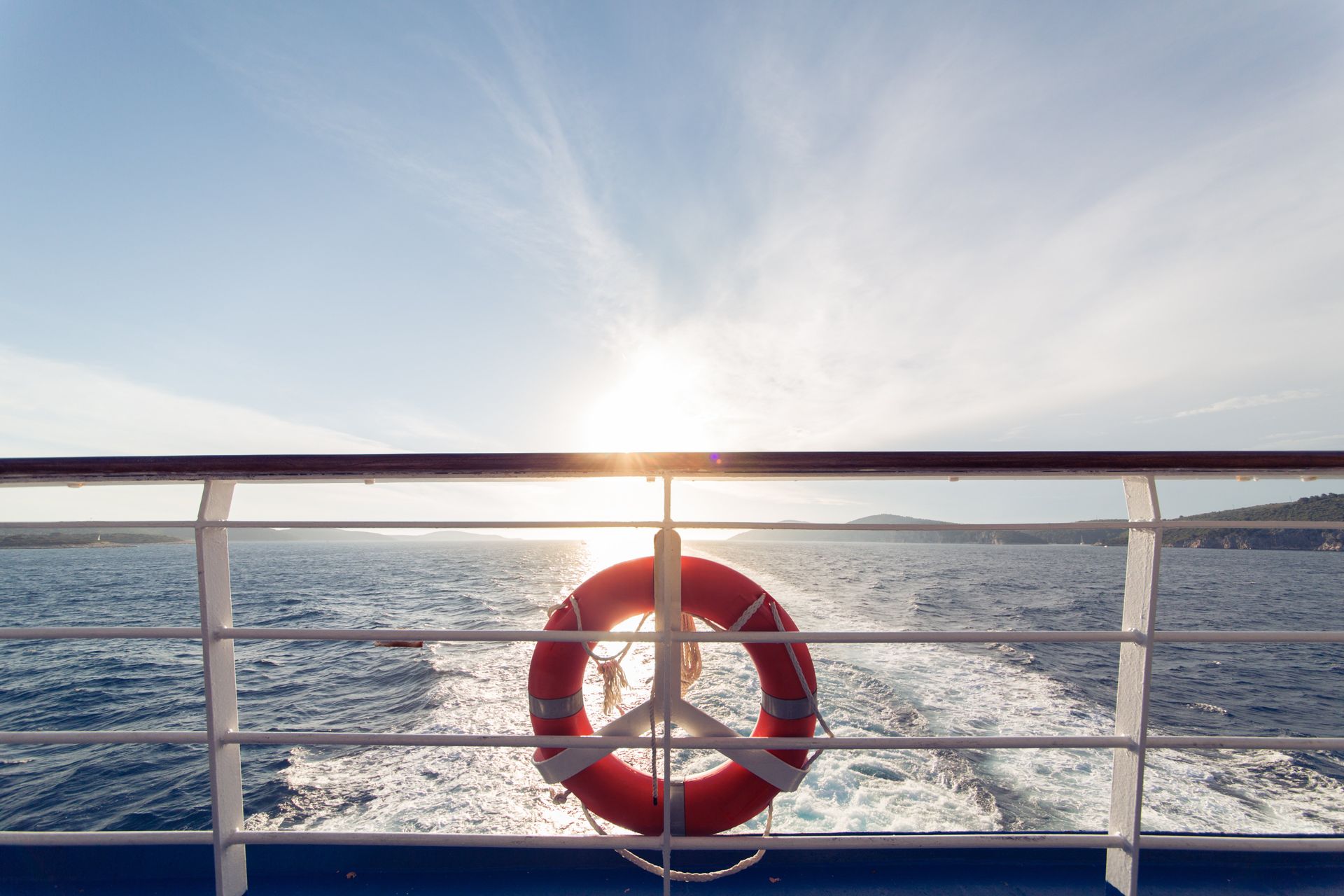 An einem Geländer eines Bootes im Meer hängt ein Rettungsring.