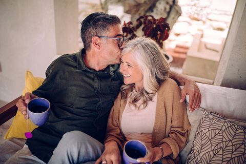 A couple sitting on their couch enjoying tea together