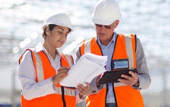 Architects reading blueprints at construction site