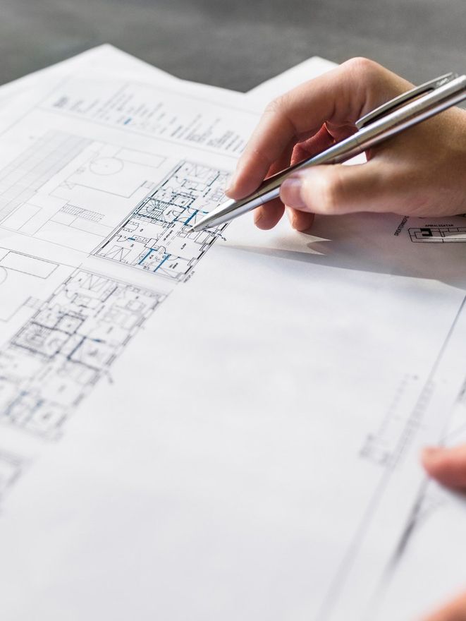 Cropped image of female architect working on blueprint