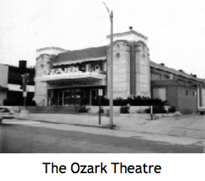 Ozark Theatre in black and white. Stone building with marquee and arched windows, on a city street.