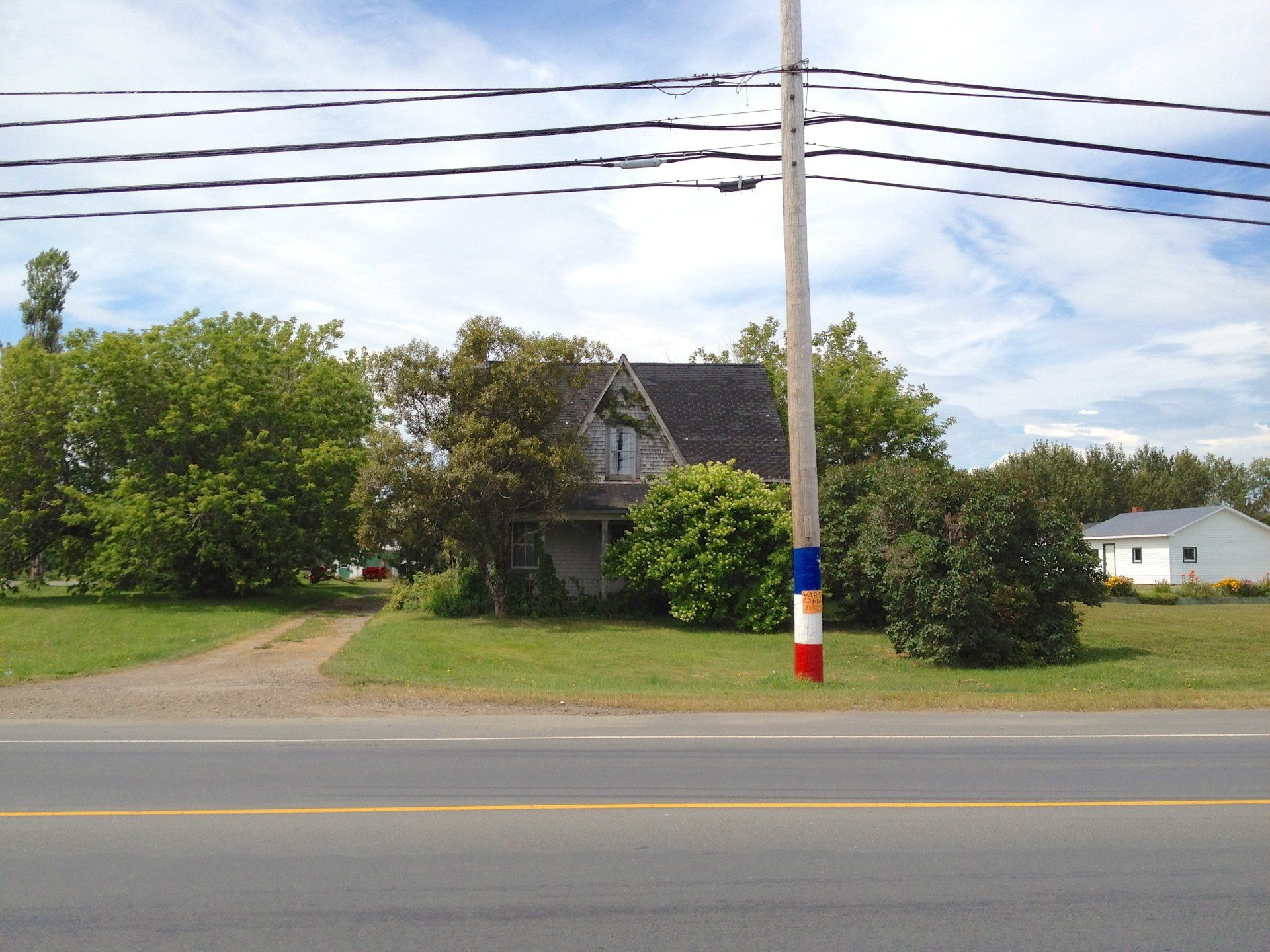 À Nigadoo, les poteaux de téléphones arborent les couleurs du drapeau de l'Acadie