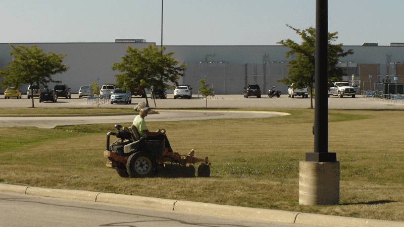 Landscaping tech from Dublin CPS, Inc. mowing a commercial field.