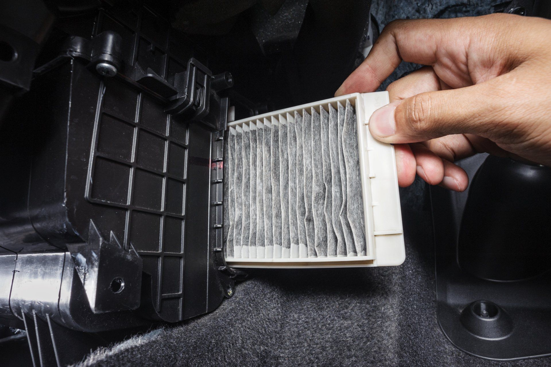 A person is holding a filter in their hand in a car.