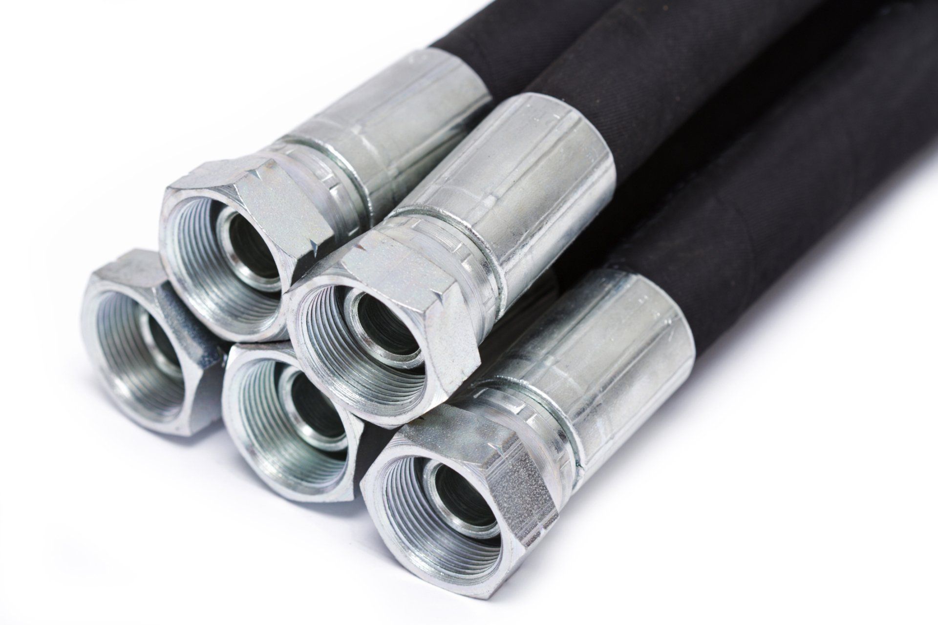 Black flexible hoses with silver metal fittings stacked together