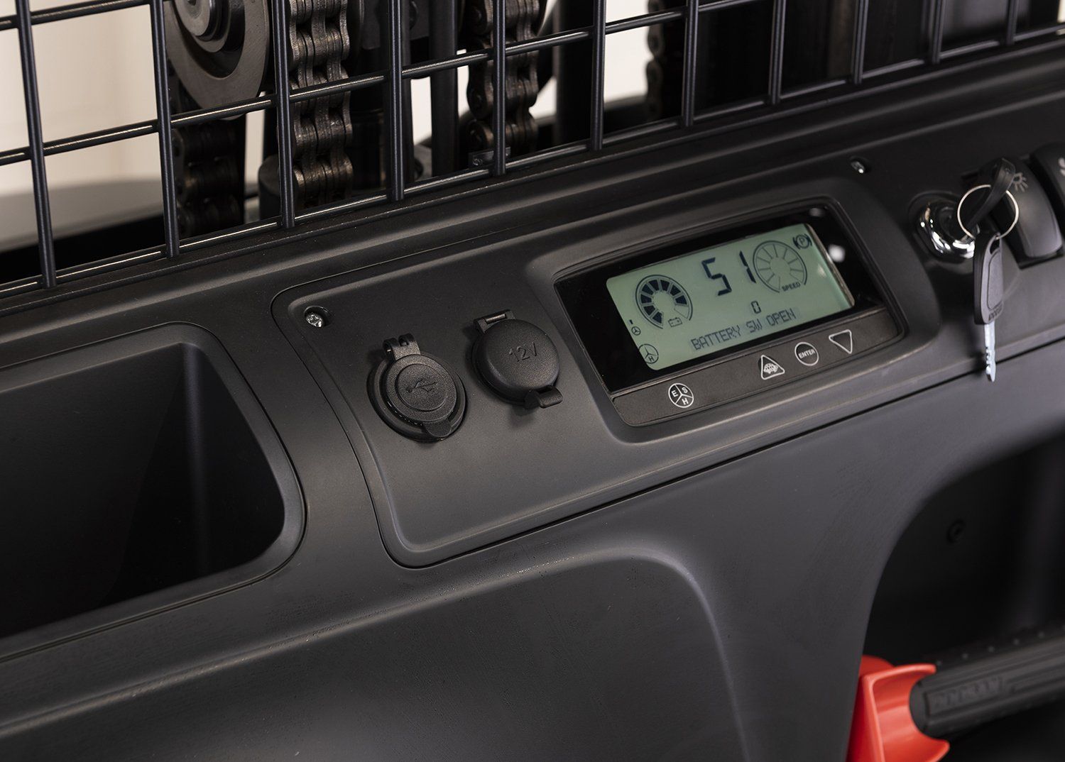 Dashboard panel with digital display, buttons, and a speaker grille in a vehicle interior