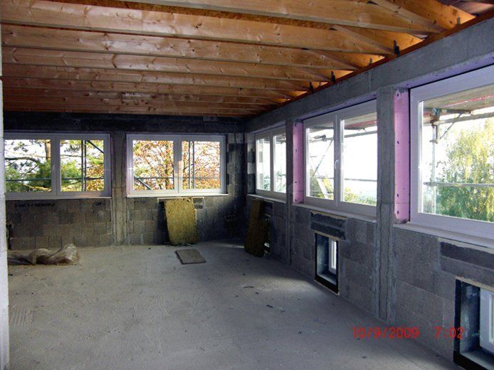 Ein leerer Raum mit vielen Fenstern und einer Holzdecke