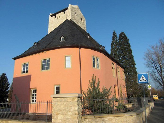 Ein großes rosa Gebäude mit einem Zebrastreifen-Schild davor