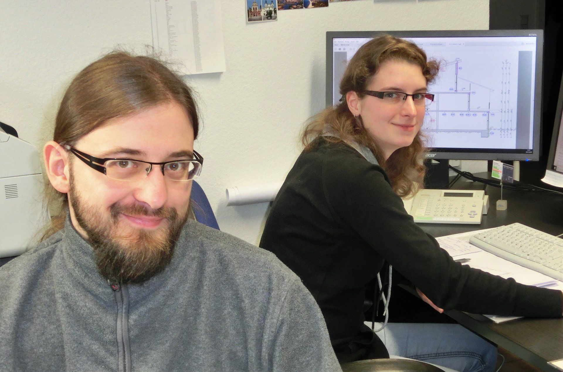 Ein Mann und eine Frau sitzen vor einem Computer