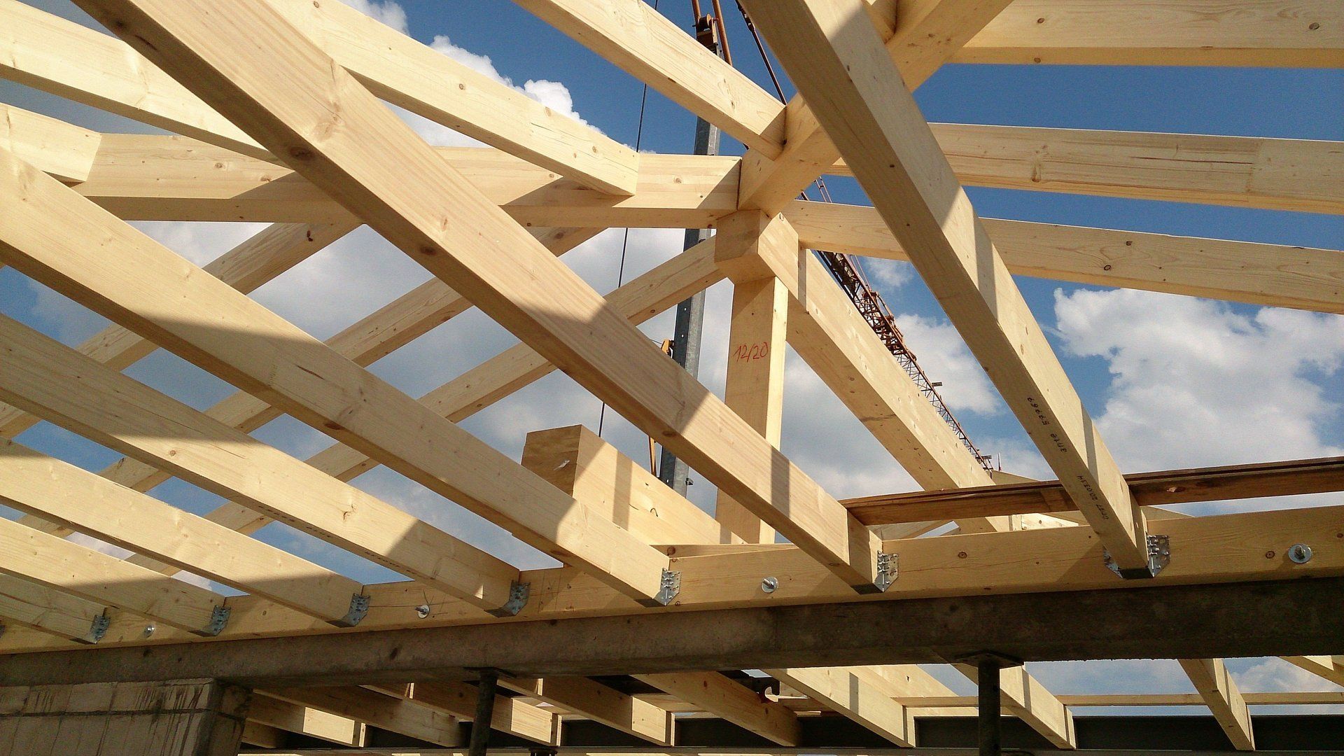 Eine Holzkonstruktion wird mit einem blauen Himmel im Hintergrund gebaut