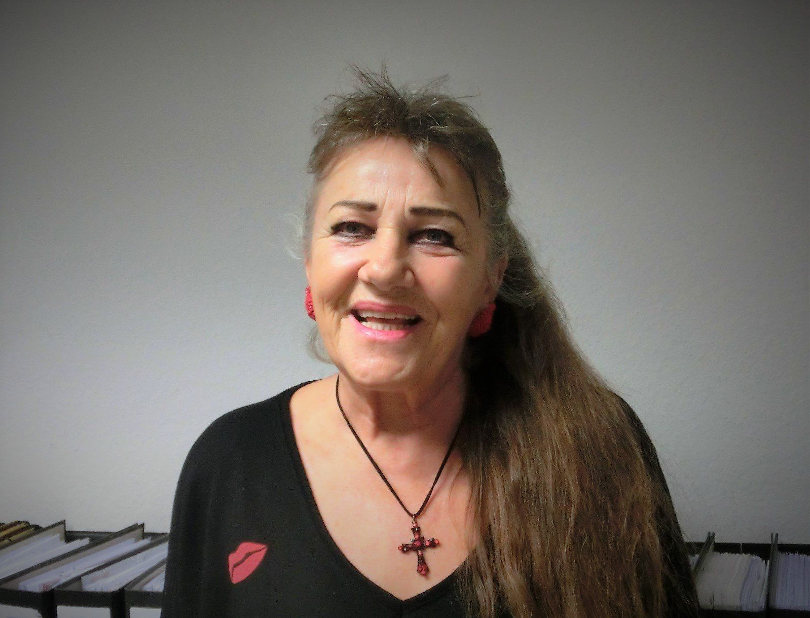Eine Frau mit einem schwarzen Hemd und einer Kreuzkette