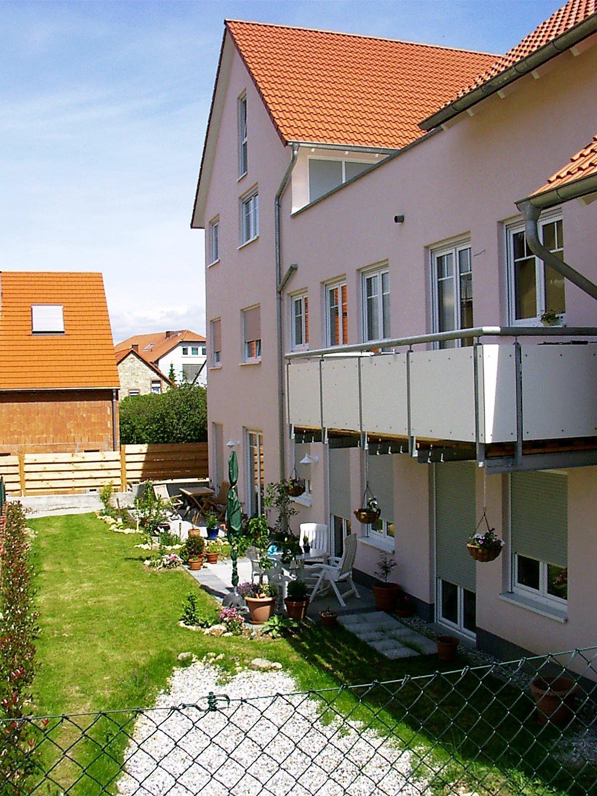 Ein Haus mit Balkon und einem Zaun davor