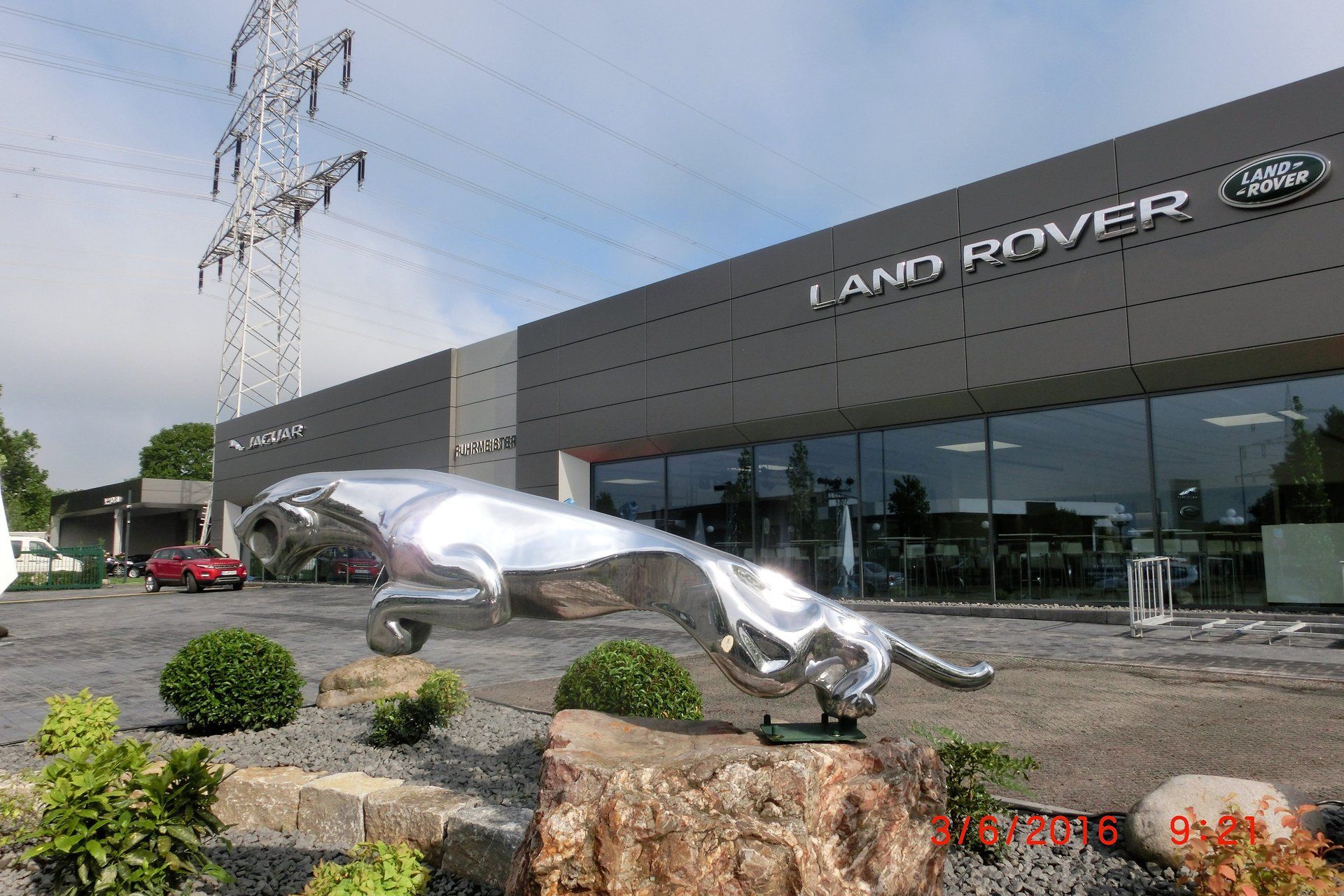 Eine Statue eines Jaguars steht vor einem Land Rover-Händler