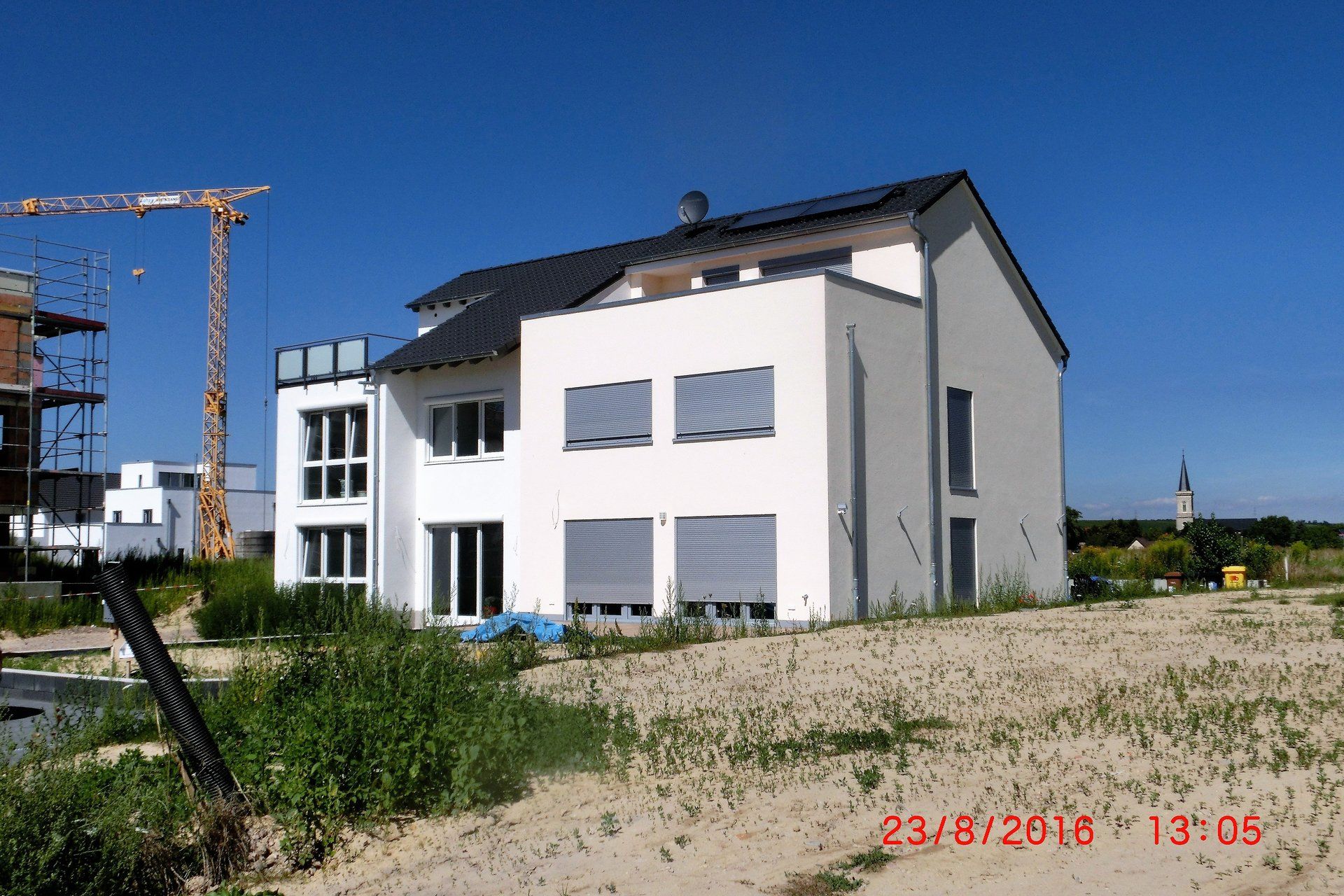 Ein großes weißes Haus mit einem Kran im Hintergrund