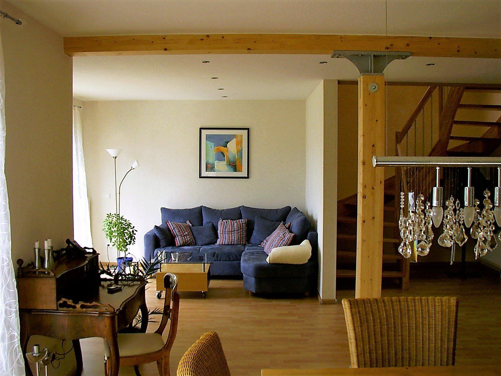 Ein Wohnzimmer mit einer blauen Couch und einem Bild an der Wand